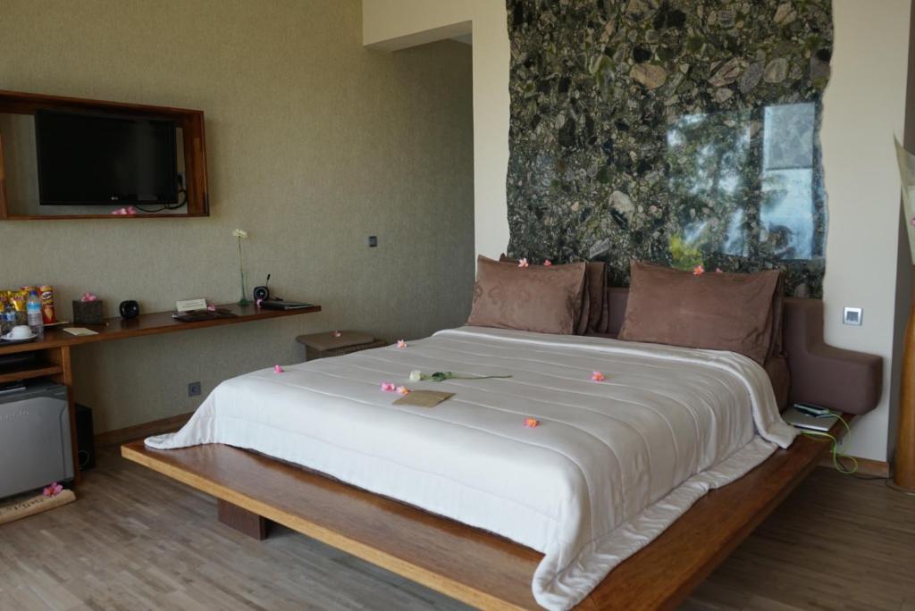 a bedroom with a large white bed in a room at The Puncak Lombok in Senggigi