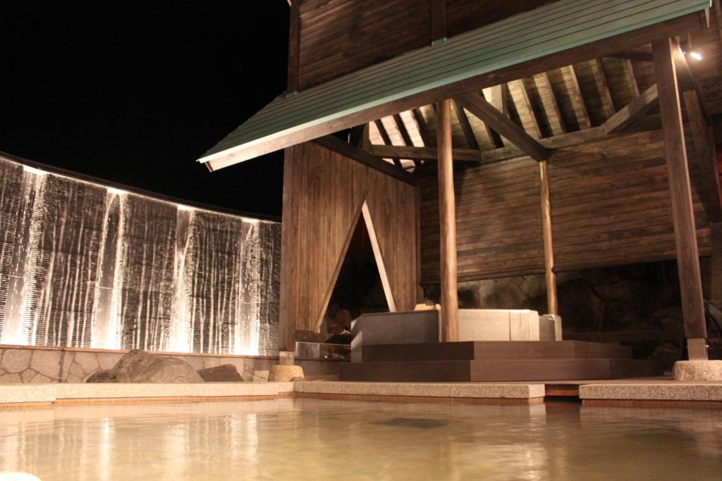 a swimming pool with a water feature in a house at Kusatsu Onsen Hotel Village in Kusatsu