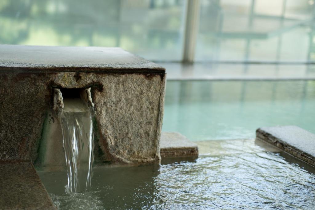 a water fountain with water coming out of it at Kusatsu Onsen Hotel Village in Kusatsu
