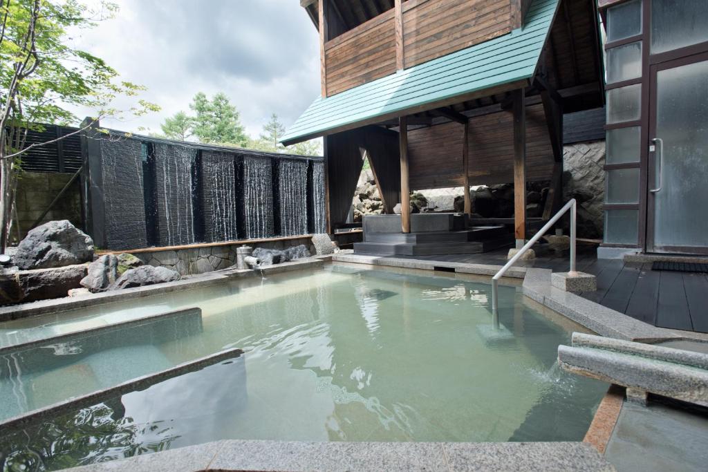 a swimming pool in front of a house at Kusatsu Onsen Hotel Village in Kusatsu