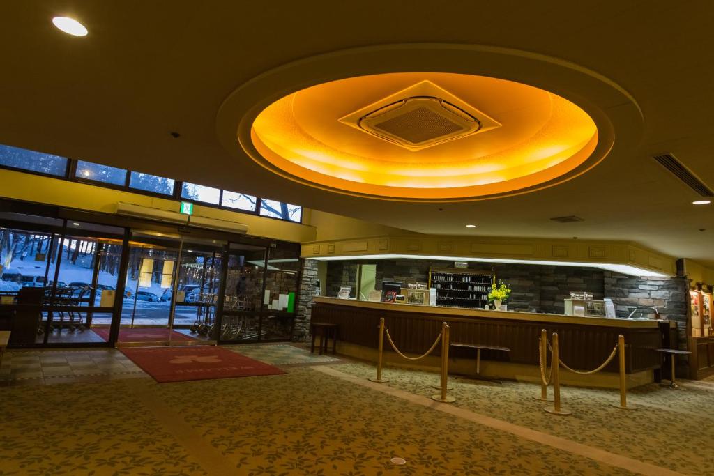 a lobby of a restaurant with a large yellow ceiling at Kusatsu Onsen Hotel Village in Kusatsu