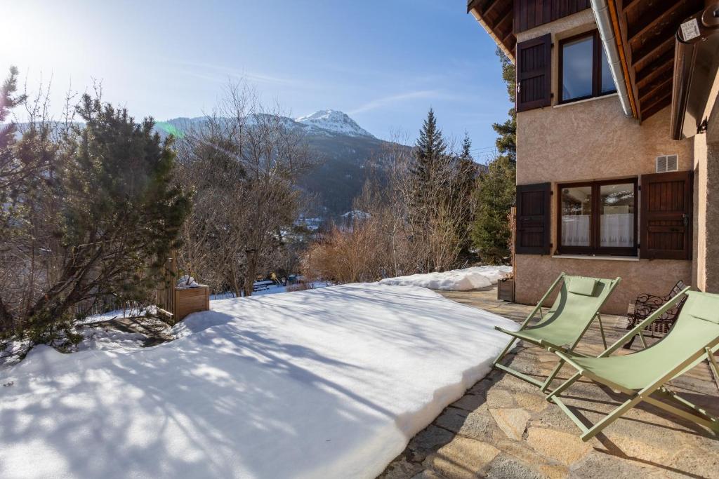a couple of lawn chairs sitting in the snow at Au Fil Du Réguinier - Gîte Briançon in Briançon