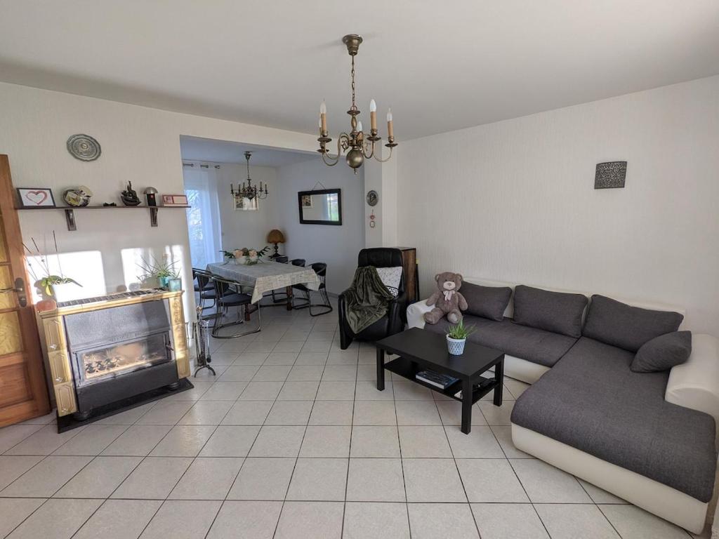 a living room with a couch and a table at LOGEMENT 110m2 CHEZ TITI in Ittenheim