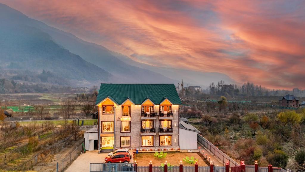 a building with a green roof with a car parked in front at Hotel Classy Castle in Kolur