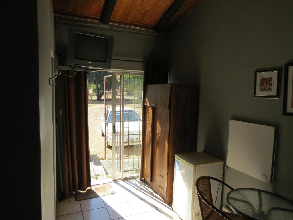 a room with a door to a patio with a television at De Villas Guesthouse in Ermelo