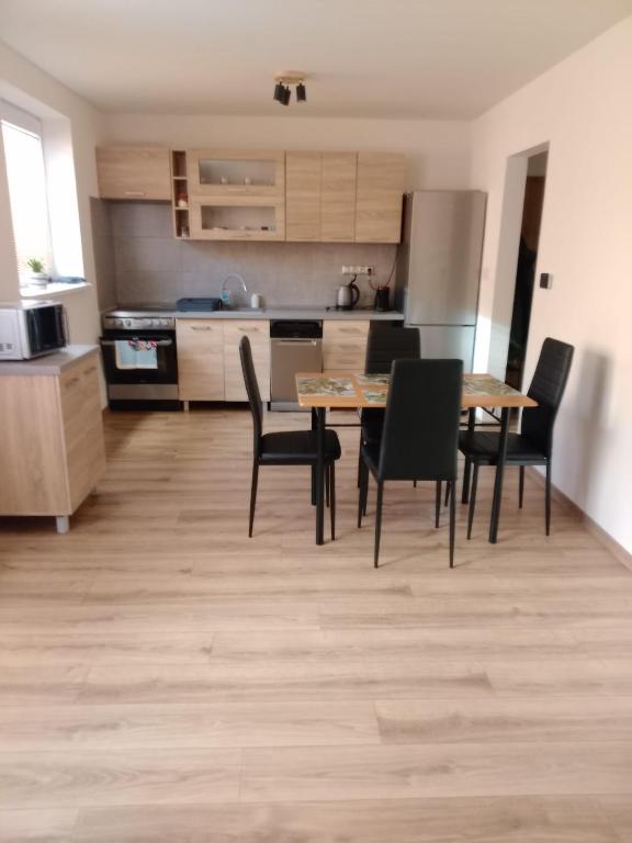 a kitchen with a table and chairs in a room at APARTMÁN KATKA Stošice - Liptovský Mikuláš, súkromie & pohodlie in Liptovský Mikuláš
