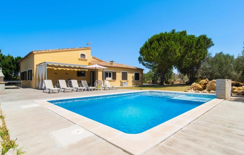 a villa with a swimming pool in front of a house at Can Paxaco in Alcudia