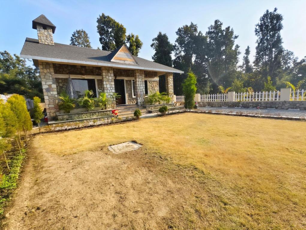 a house with a large yard in front of it at Basera by the Woods in Dehradun