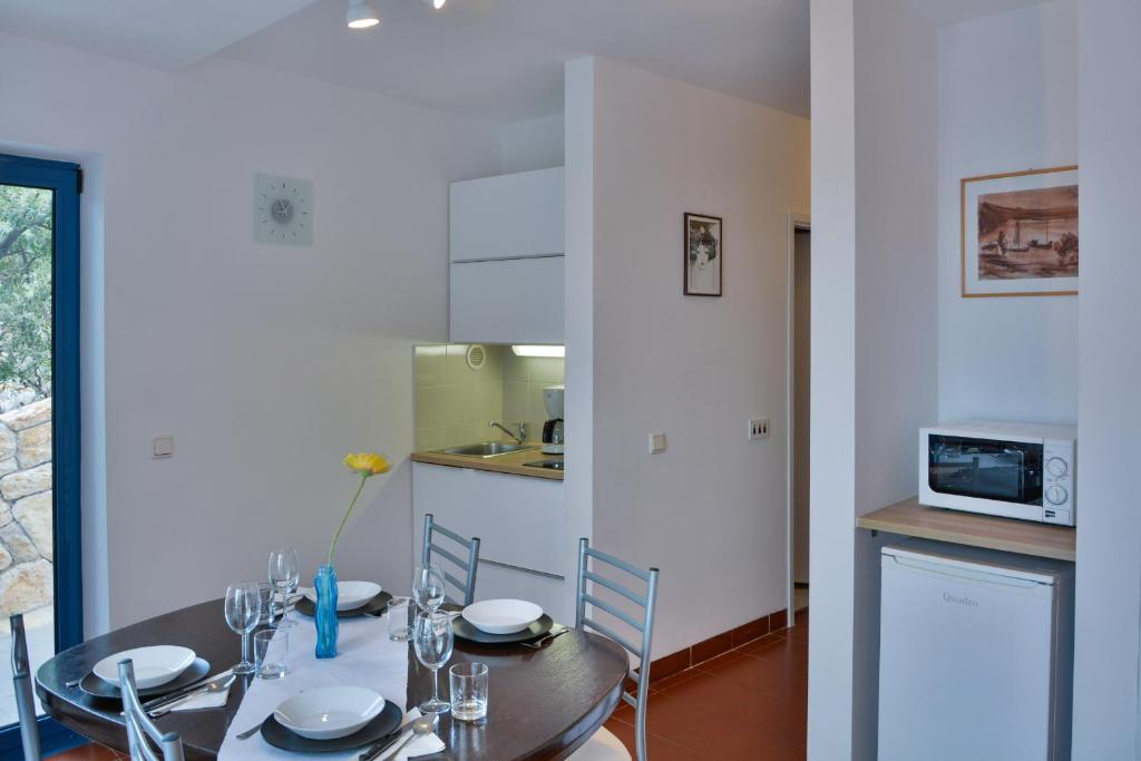 a kitchen and dining room with a table and chairs at Apartments Miki in Donja Klada