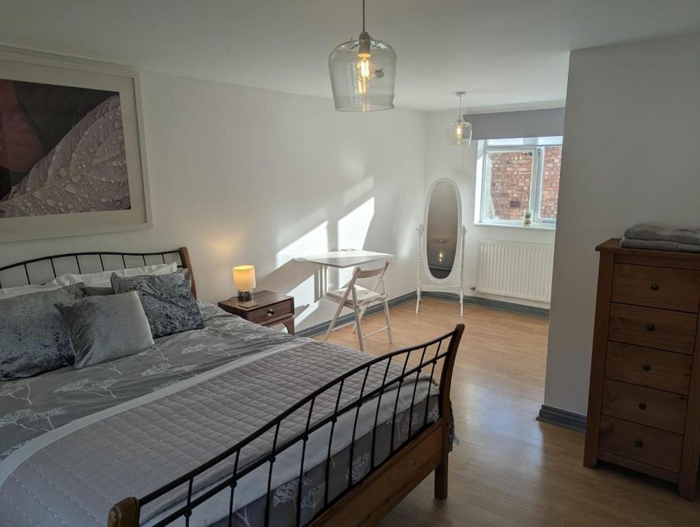 a bedroom with a bed and a table and a chair at Romeo's Retreat in Stratford-upon-Avon