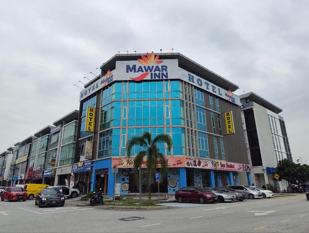 a large building with a sign on top of it at Hotel Mawar Inn in Jenjarum