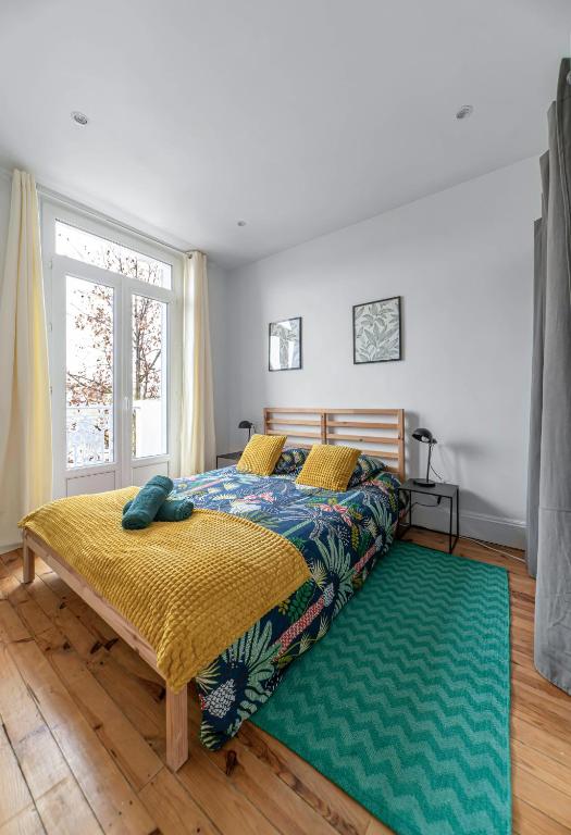 a bedroom with a bed and a green rug at Résidence Celestins - Appartements centre avec parking in Vichy