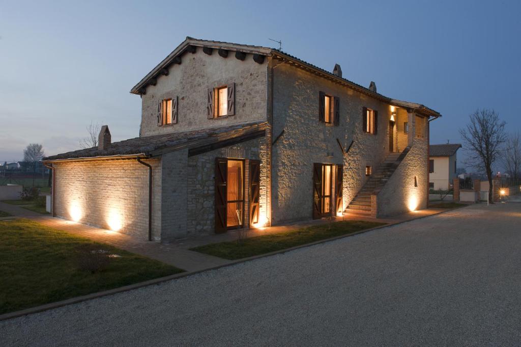 an old stone house with lights on a street at Casale Marroggia in Foligno