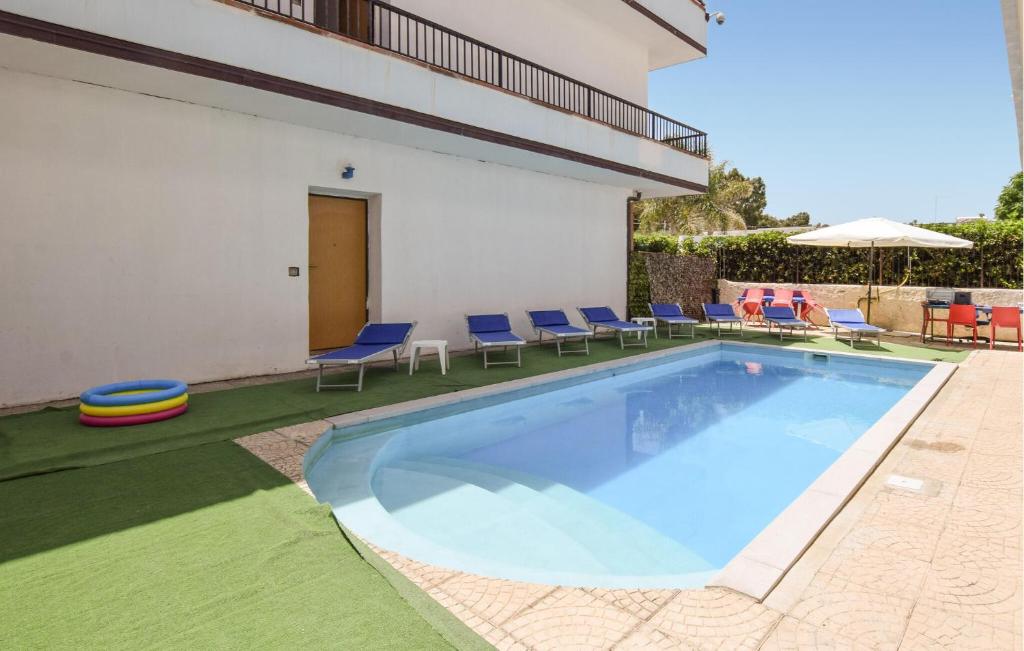 a pool with chairs and a frisbee next to a building at Awesome Apartment In Palmi in Palmi