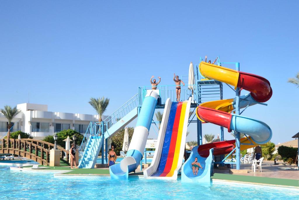 a water slide in a swimming pool with people on it at Queen Sharm Aqua Park Hotel in Sharm El Sheikh