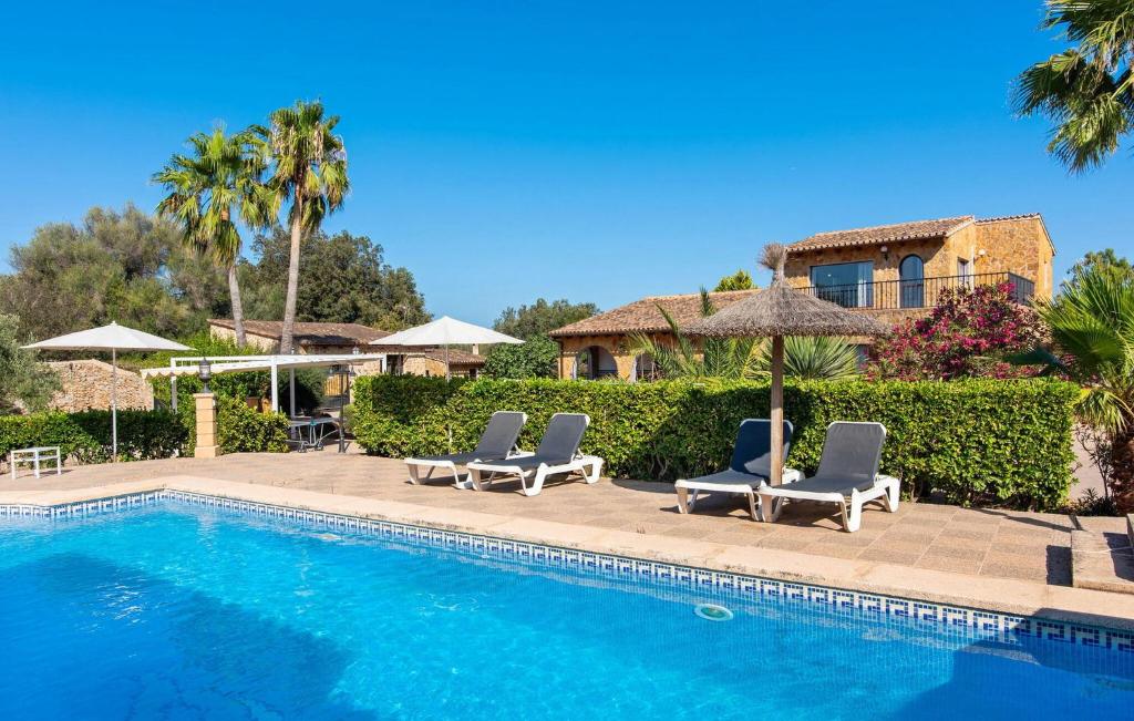 a swimming pool with two lounge chairs and a house at Na Peixet in Artá