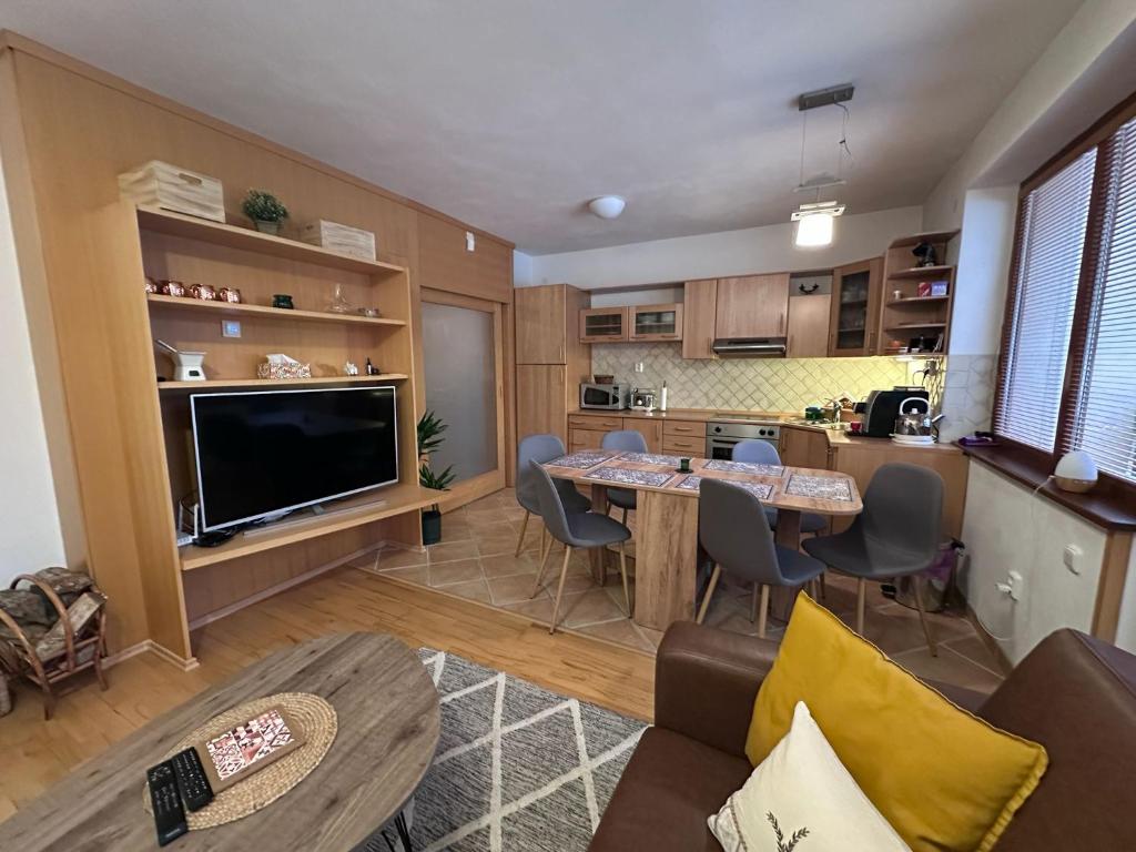 a living room with a table and a kitchen at Apartmán Donovaly 90 in Donovaly