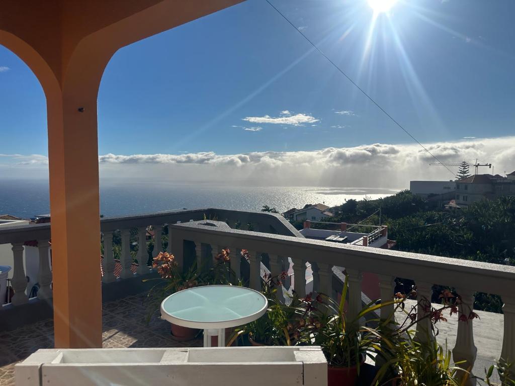 a balcony with a table and a view of the ocean at Casa Mary Bela's in Ponta do Sol