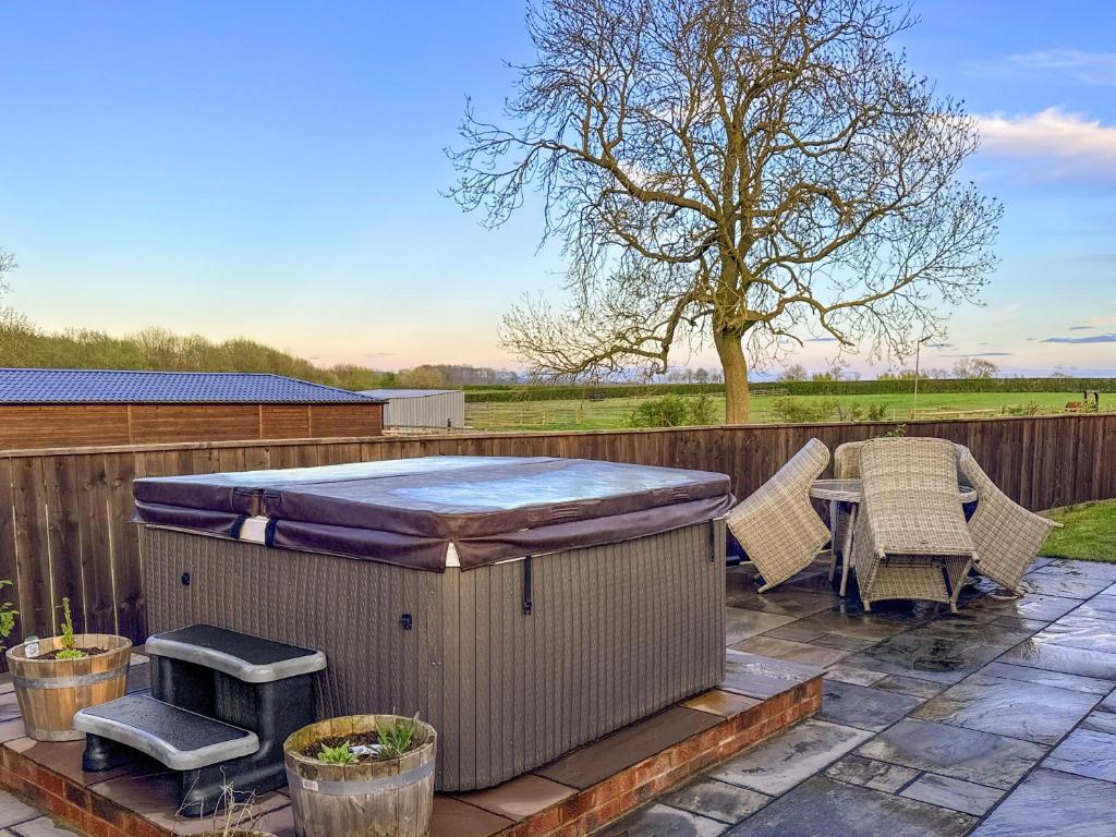a hot tub on a patio with a table and chairs at Cleveland View Cottage in North Cowton