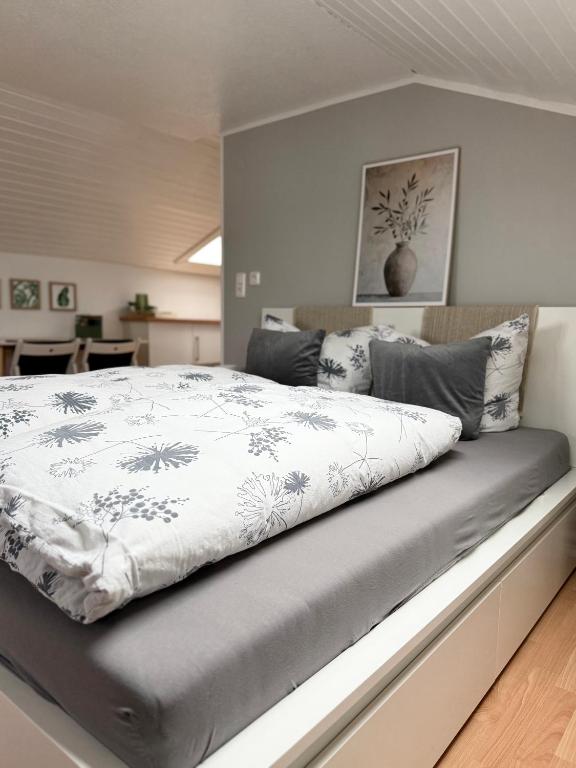 a bedroom with a bed with a gray and white comforter at Refugium by Zirwick Apartment in Weiherhammer