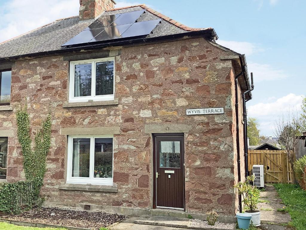 an old brick house with a solar roof at Seasgair in Dingwall