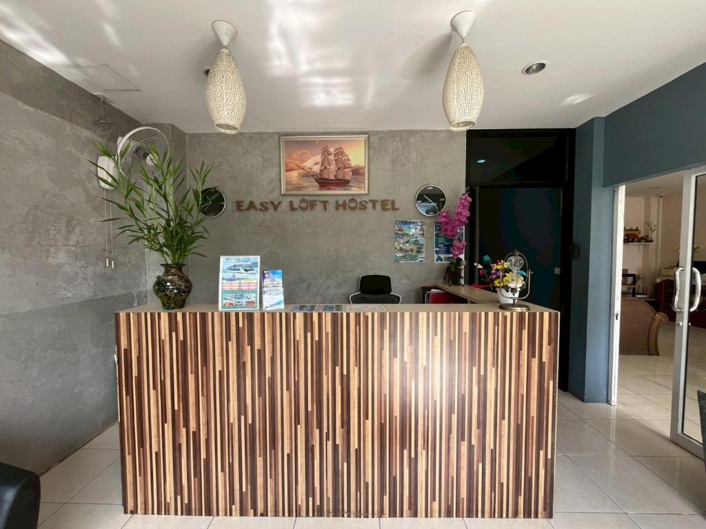 a lobby with a wooden counter with a vase on it at Easy Loft Hostel in Phuket