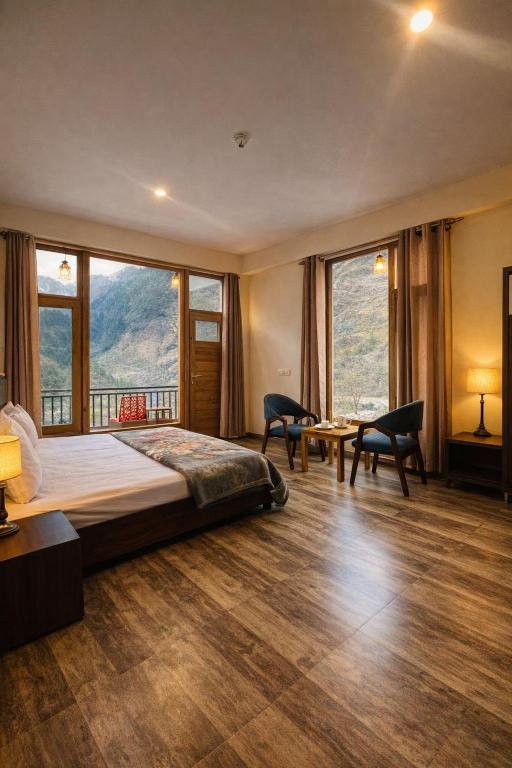 a bedroom with a large bed and large windows at North star Manali in Vashisht