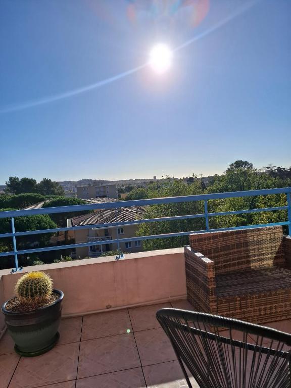 a balcony with two chairs and a cactus at Appartement Riposa in Fréjus