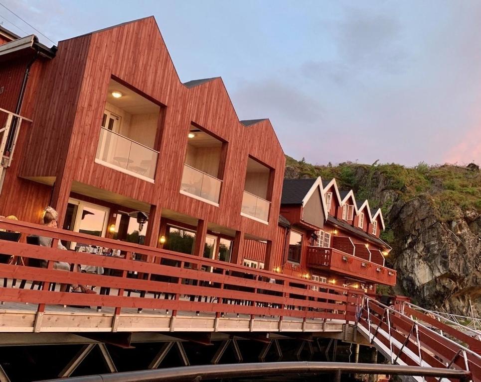 a building on a bridge next to a mountain at Kuringen Brygge Hotel and Restaurant in Refsnes