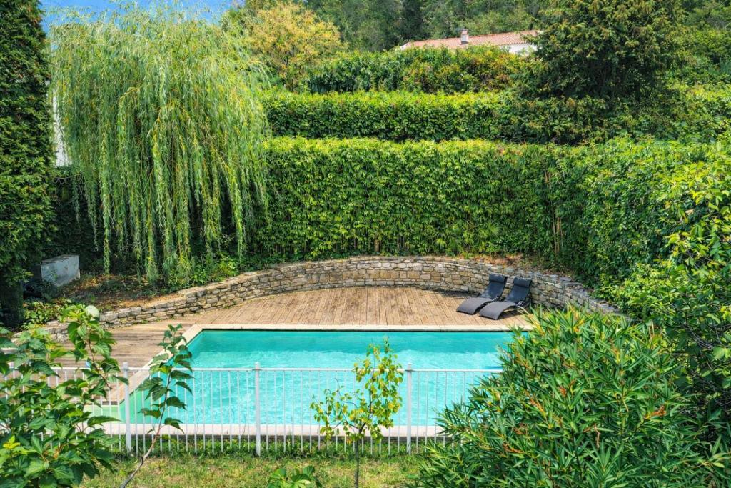 a swimming pool in the middle of a garden at Villa Lanaka in Grabels
