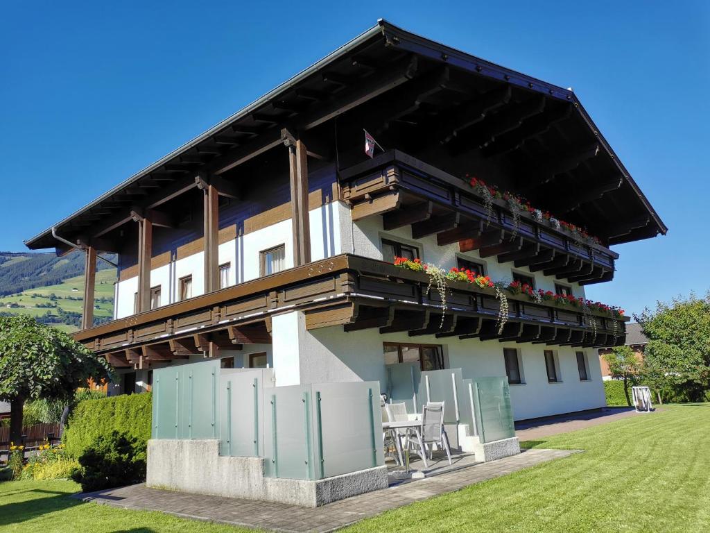 a building with chairs and flowers on the balcony at Privatzimmer Haus Lienbacher in Mittersill