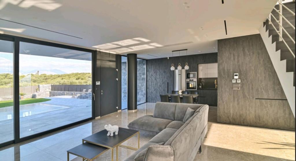 a living room with a couch and a table at Palme Luxury Villa in Galatás