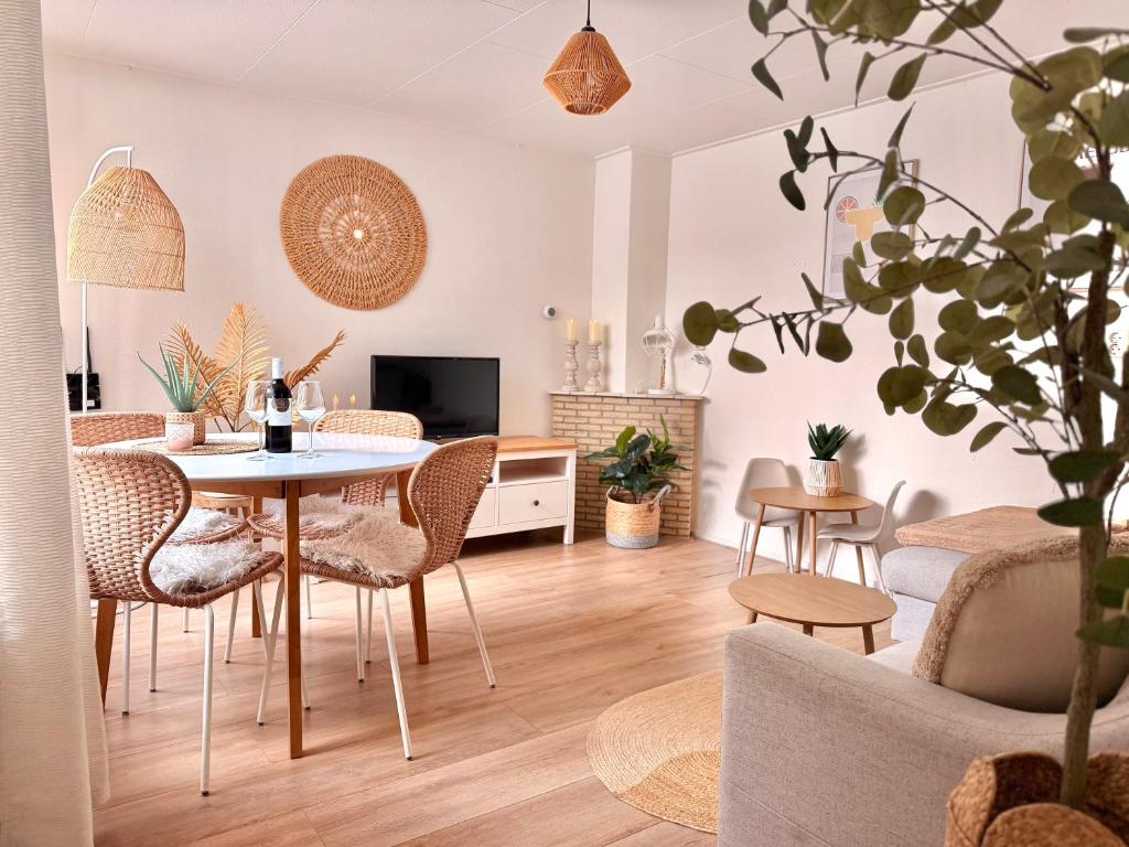 a living room with a table and chairs at Beach House Sea-Esta in Egmond aan Zee