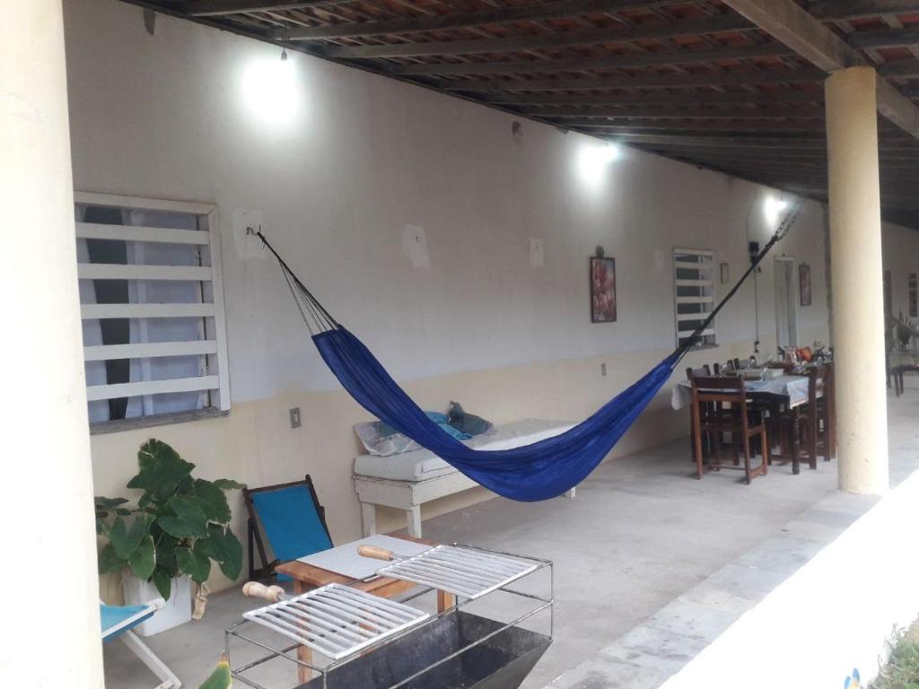 a hammock hanging in a room with a table at Recanto do Cajueiro - Luís Correia - Piauí in Luis Correia