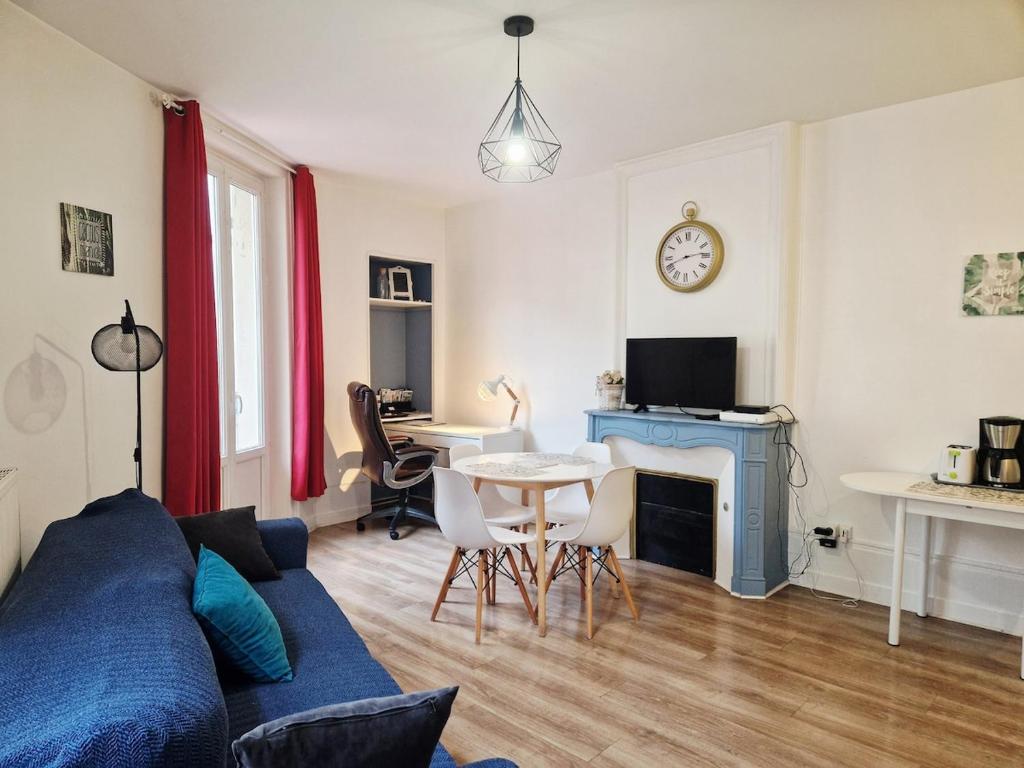 een woonkamer met een blauwe bank en een tafel bij Frégate in Cherbourg en Cotentin