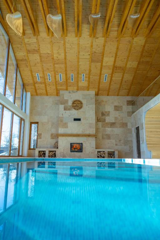 a swimming pool in a house with a ceiling at The Cliff Village in Comarnic