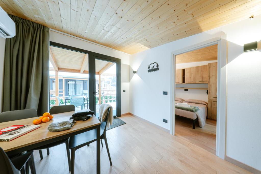 a room with a dining table and a bedroom at Sarca Lodge Val Rendena in Dare