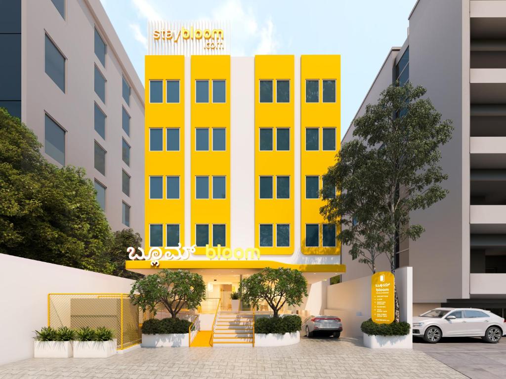 a yellow building in front of some buildings at Bloom Hotel - ISKCON Rajajinagar in Bangalore