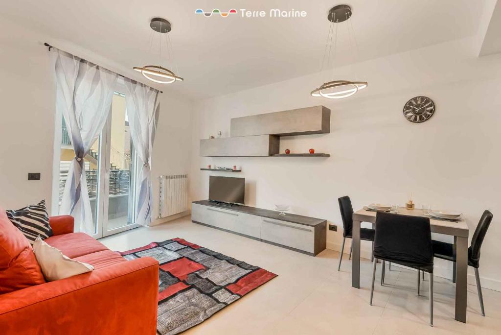 a living room with a red couch and a table at Cà del Magra, TerreMarine in Santo Stefano di Magra