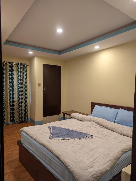 a bedroom with a large bed with a robe on it at Hotel New Airport in Kathmandu
