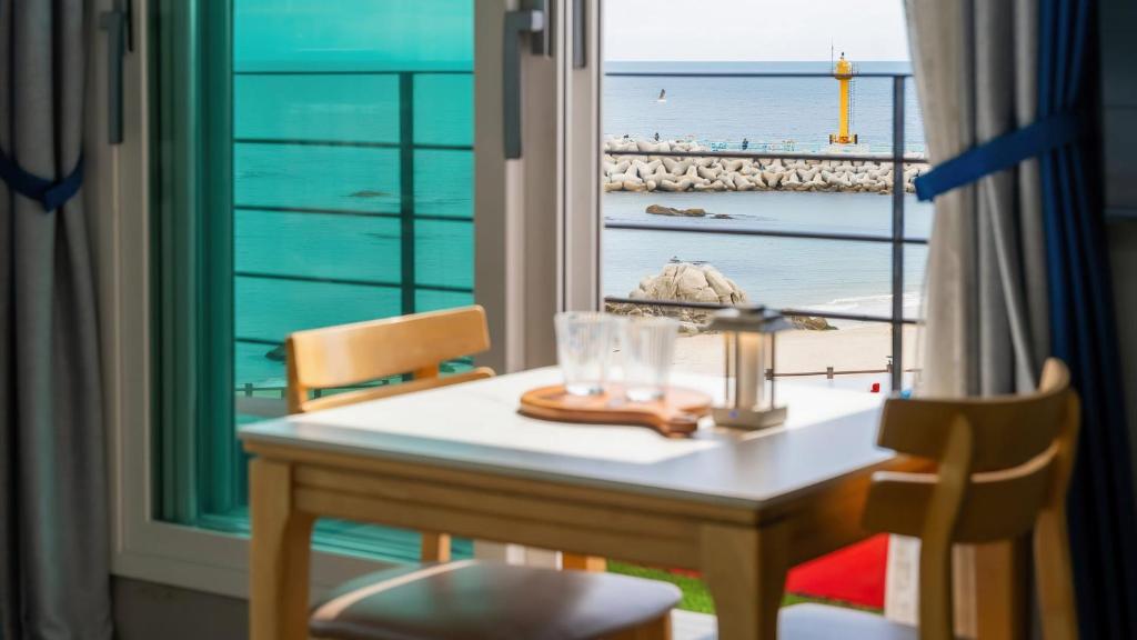 a dining table with a view of the ocean at Gangneung Glad Pension in Gangneung