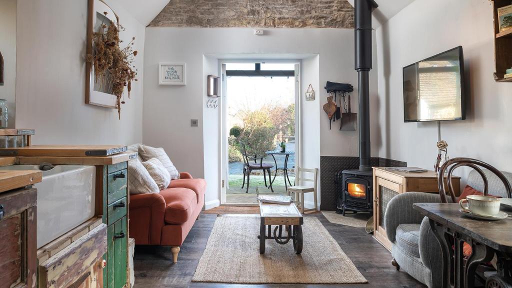 a living room with a couch and a fire place at Filly Island in South Cerney