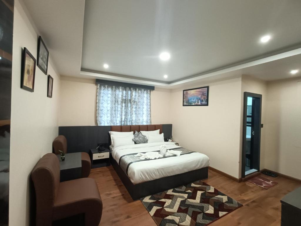 a bedroom with a bed and a chair at Hotel Paryatak in Namchi