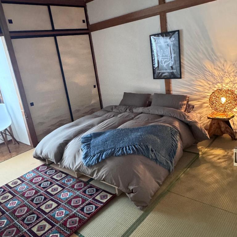 a bedroom with a large bed with a rug at Chill House in Myoko