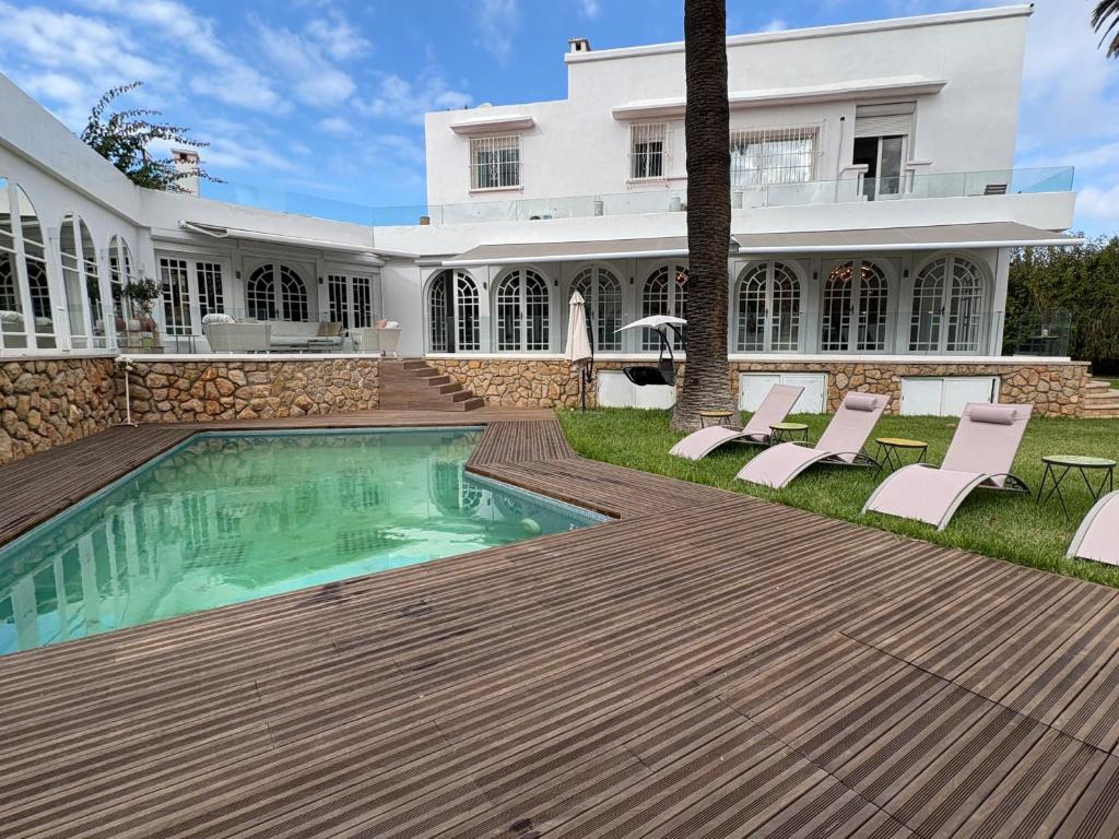 a villa with a swimming pool and a house at Palais Elya in Rabat