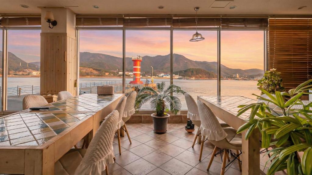 a dining room with a long table and chairs at tongyeong haegando pension in Tongyeong