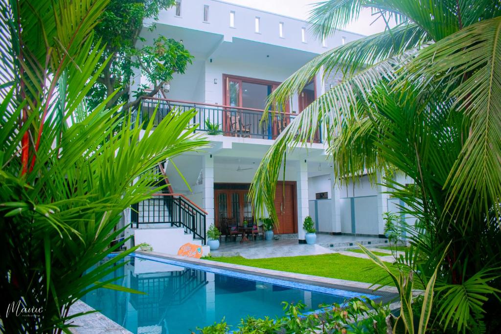 a house with a swimming pool and palm trees at Coco Leaf Apartment with Private Pool Near the Beach in Hikkaduwa