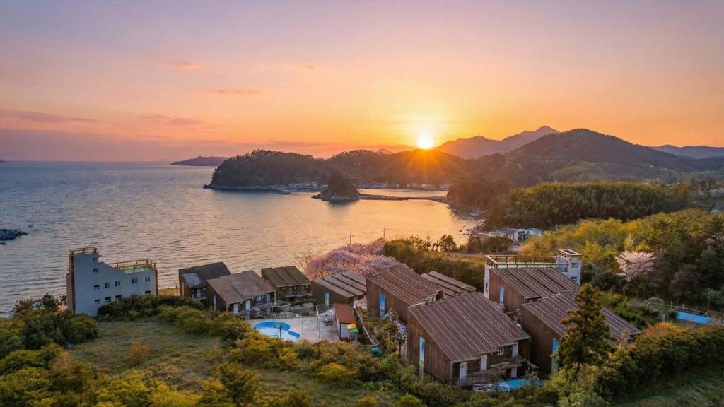 an aerial view of a village on the water at sunset at Geojedo Pilos Ocean View Pension in Geoje