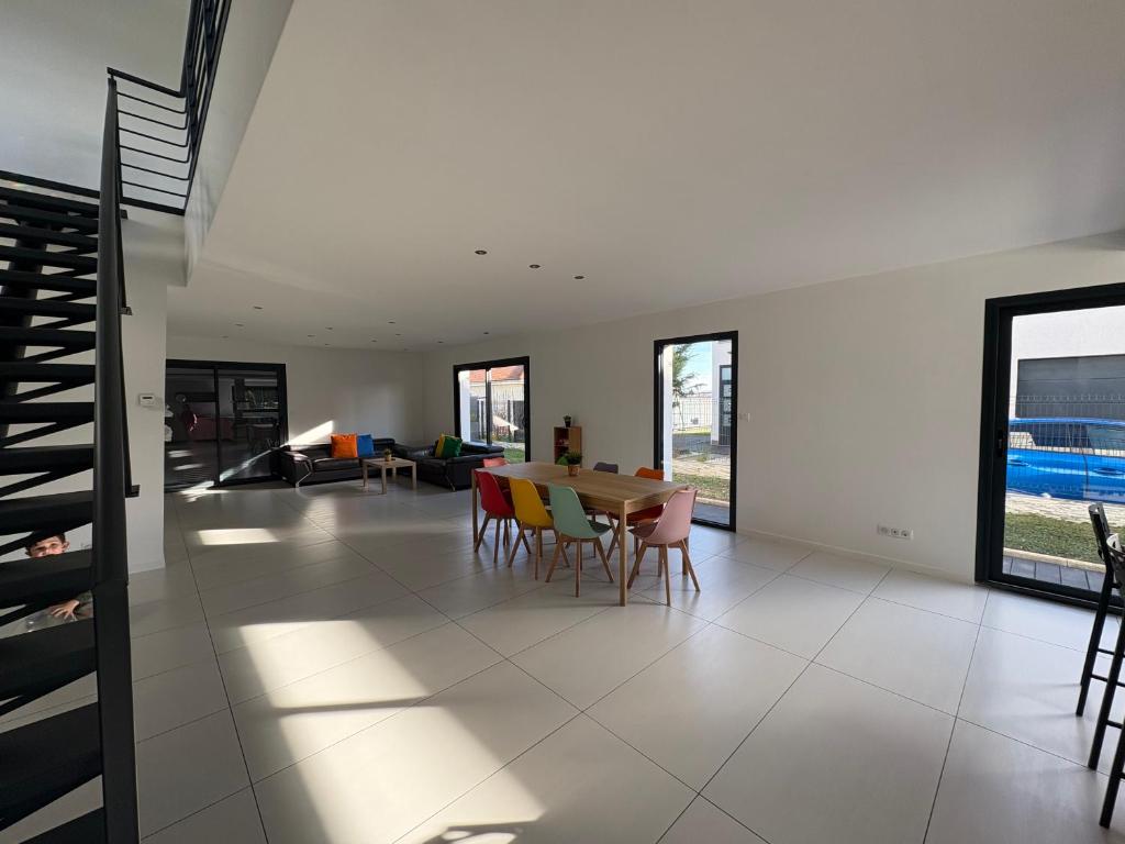 a dining room and living room with a table and chairs at Maison moderne Villa in Aulnat
