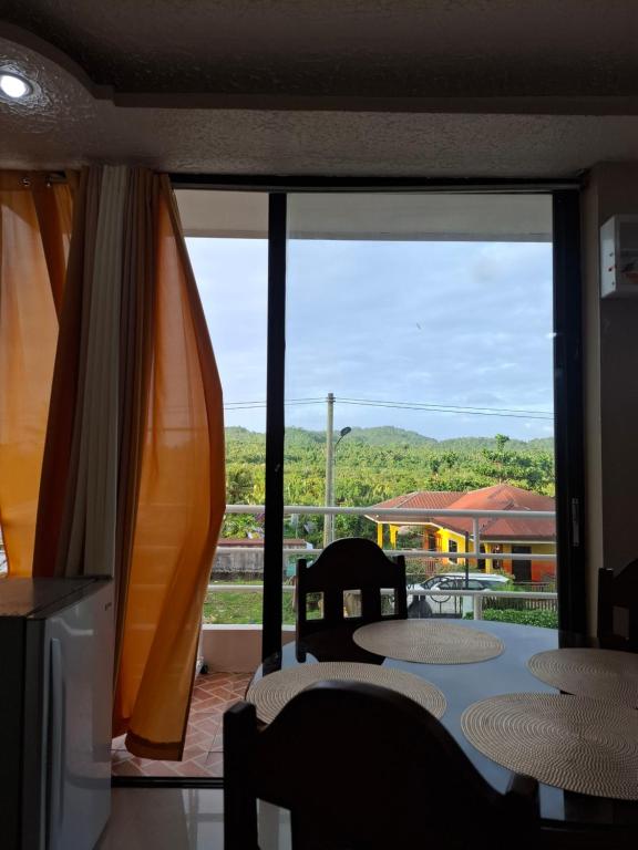 a room with a table and chairs and a large window at Imari's Apartment in San Isidro